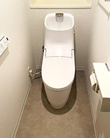 落ち着いたモルタル風の床と厚みとパールが特徴のホワイトの壁紙を合わせたトイレリフォーム事例画像|LIXIL(INAX) プレアスHSの施工